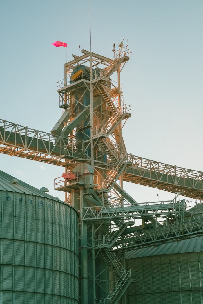 A towering industrial structure with metal walkways against a clear sky backdrop.